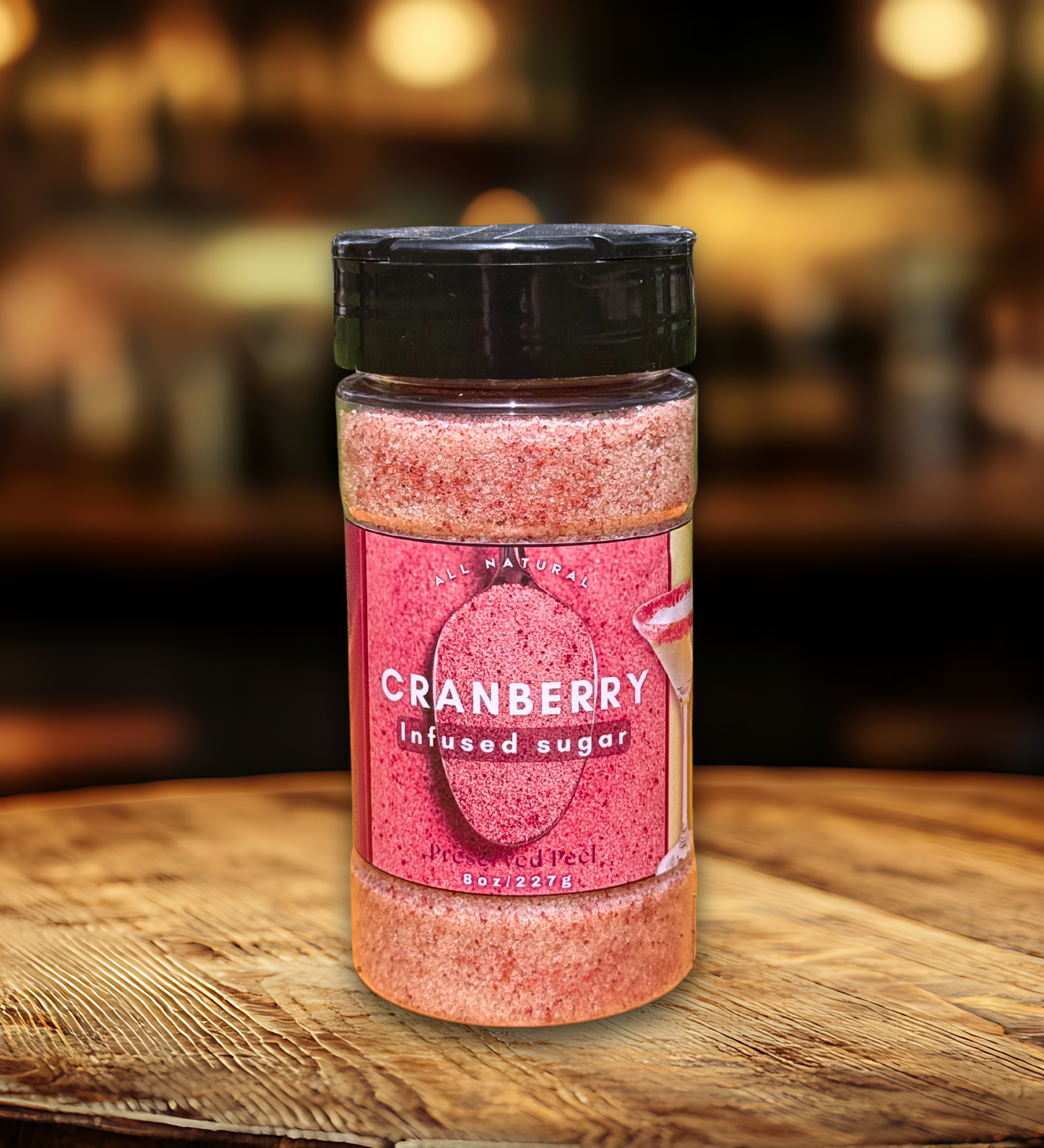 Jar of cranberry infused sugar on a wooden surface with a blurred background