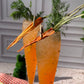 Carrot-shaped cocktails with garnishes on a checkered cloth against a neutral background