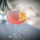 Dried fruit slice in a pink cocktail, a half dried orange slice, premium cocktail garnish, dehydrated fruits 